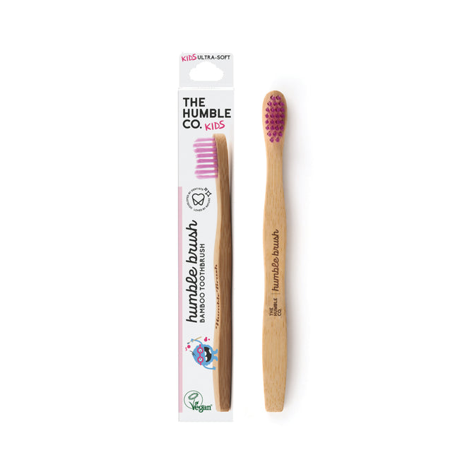 The Humble Co.s Kids Bamboo Toothbrush - Ultra Soft features nylon bristles with pink tips. Beside the vibrant box, this vegan toothbrush ensures a gentle brushing experience for children.