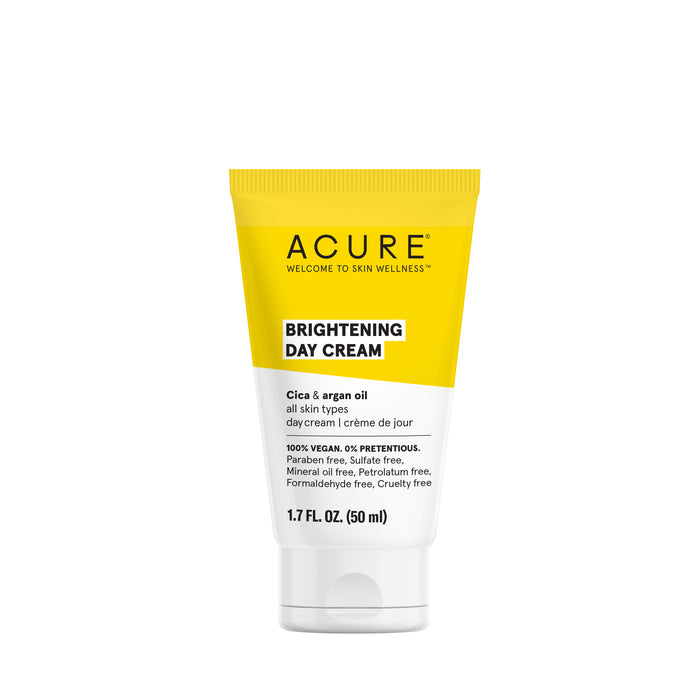 A yellow and white tube of Acure Brightening Day Cream with Cica and argan oil, labeled for all skin types, 1.7 fl oz (50 ml), and highlighting its vegan and cruelty-free formula.