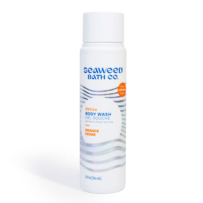 A white bottle of Seaweed Bath Co. Detox Body Wash in Orange Cedar scent with a silver wave design and blue text, standing upright against a plain white background.