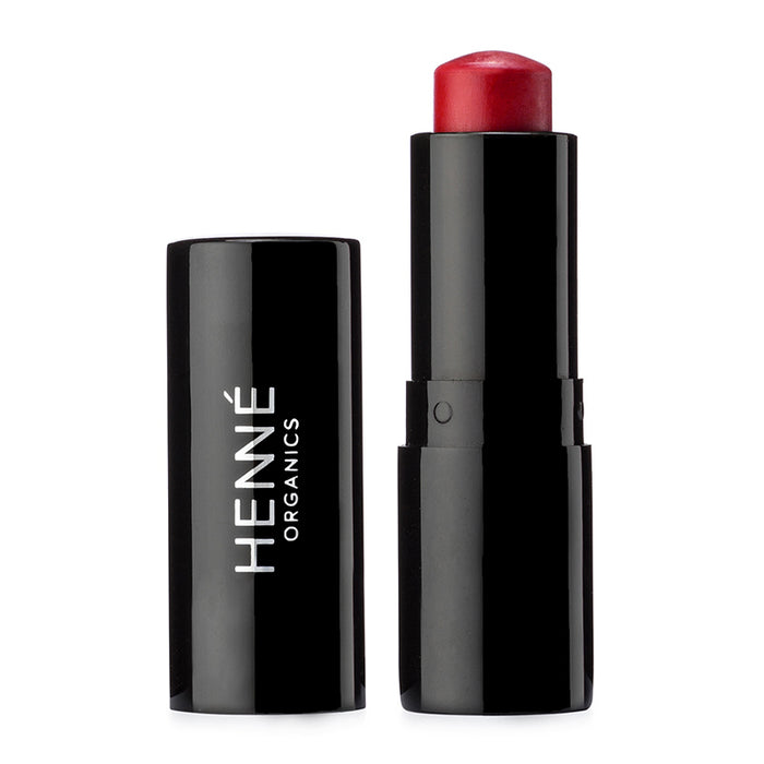A black lipstick tube labeled HENNÉ ORGANICS stands next to its matching cap, revealing a red-toned lipstick inside. The background is white.