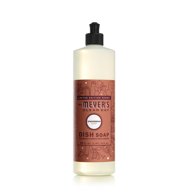 Mrs. Meyers Dish Soap, in a 16 fl oz bottle, is a limited edition featuring a gingerbread scent and decorated with white floral and kitchen-themed illustrations on its brown label.