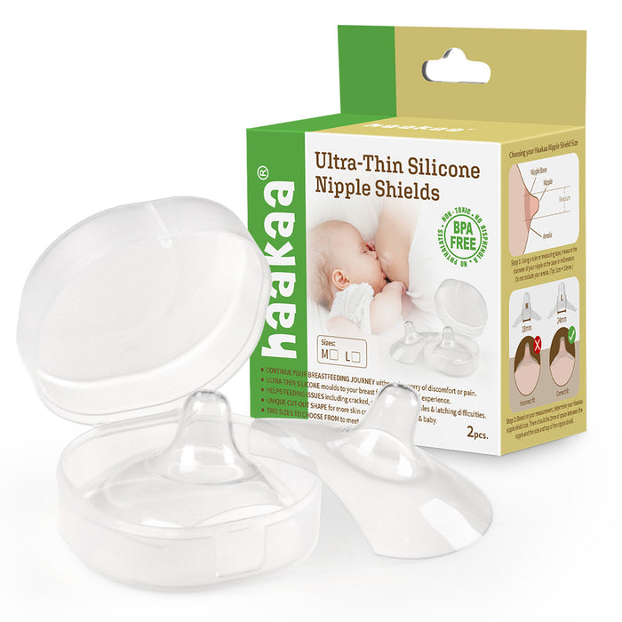 A clear plastic case with two ultra-thin silicone nipple shields is shown in front of a green and beige Haakaa product box featuring a baby, product details, and usage instructions.