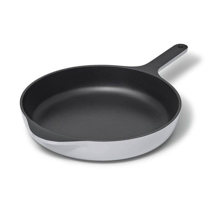 A black cast iron skillet with a shiny silver exterior and a long handle, shown on a white background.