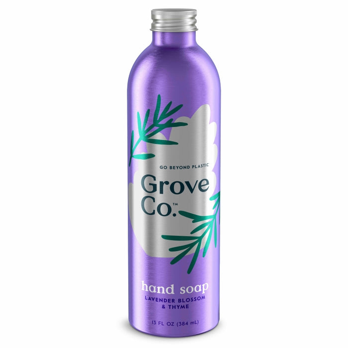A purple metallic bottle of Grove Co. hand soap with lavender blossom and thyme scent, featuring green leaf illustrations and a silver cap. The label highlights “Go Beyond Plastic” above the brand name.