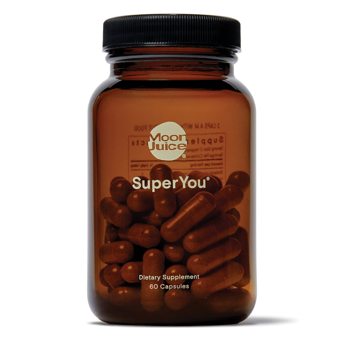 A brown glass bottle labeled Moon Juice SuperYou containing dark capsules. The label also reads Dietary Supplement, 60 Capsules. The bottle has a black screw cap.