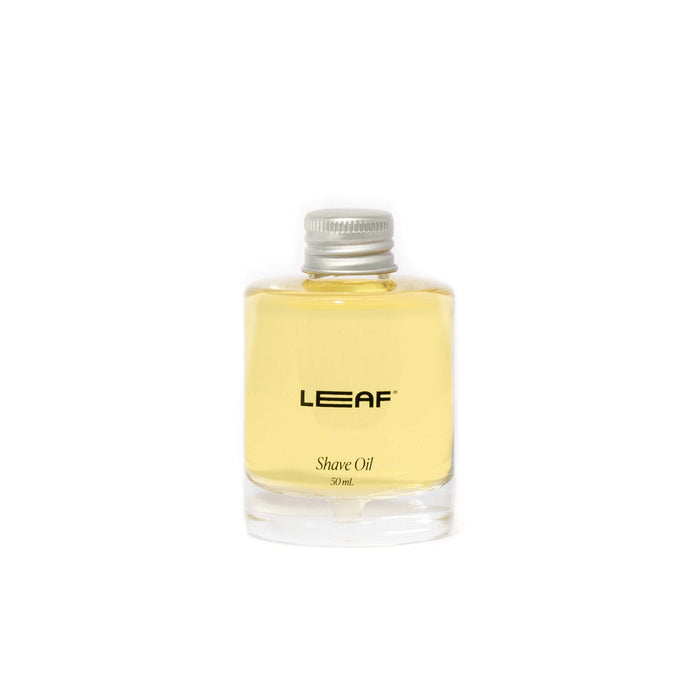 A small, clear glass bottle labeled LEAF Shave Oil 50ml with a silver screw cap, filled with light yellow oil, set against a plain white background.