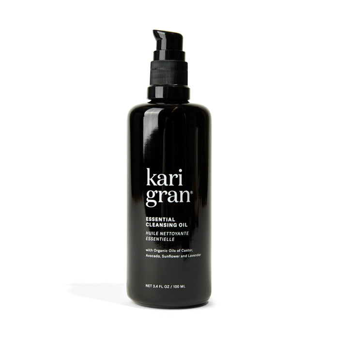 A black pump bottle labeled Kari Gran Essential Cleansing Oil with text noting organic oils of camellia, avocado, sunflower, and lavender. The bottle contains 3.4 fl oz (100 ml).