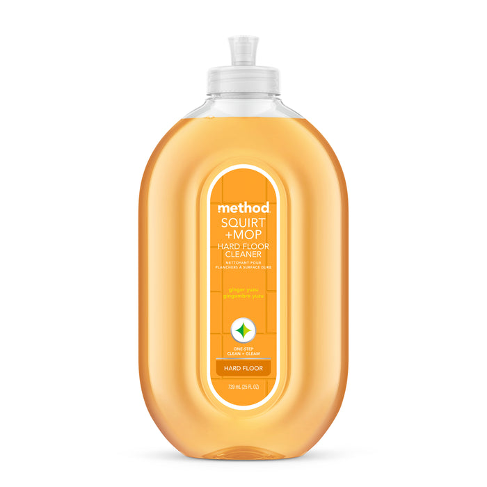 A bottle of Method Squirt + Mop Hard Floor Cleaner in orange scent, with a clear cap and orange liquid inside. The label features product details and icons for wood and hard floors.