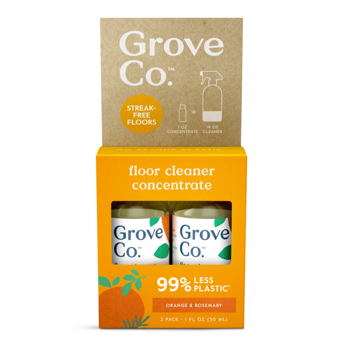 Two bottles of Grove Co. floor cleaner concentrate in orange and brown packaging. The label highlights “99% less plastic” and “orange & rosemary.” The box also shows “streak-free floors” and a recycle symbol.