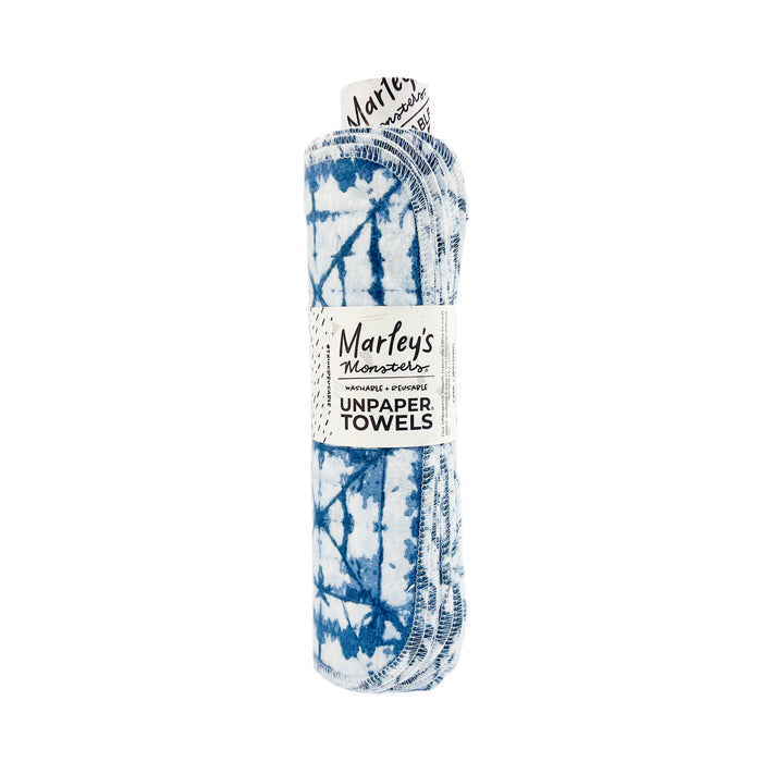 A rolled bundle of Marleys Monsters UNPAPER TOWELS with a blue and white tie-dye pattern, secured with a labeled paper band.