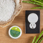 A scent diffuser plugged into an outlet, a tin labeled enviroscent sea salt & aloe scratch + sniff, coarse salt in a wooden bowl, and aloe leaves on a wooden surface.