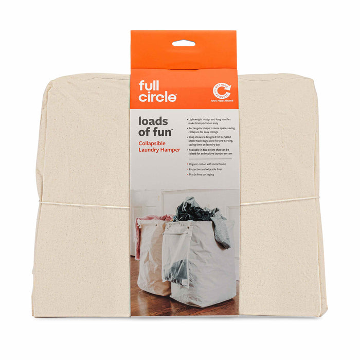 A folded Full Circle Loads of Fun collapsible laundry hamper in beige packaging, showing a product image of two open hampers filled with laundry on a hardwood floor.