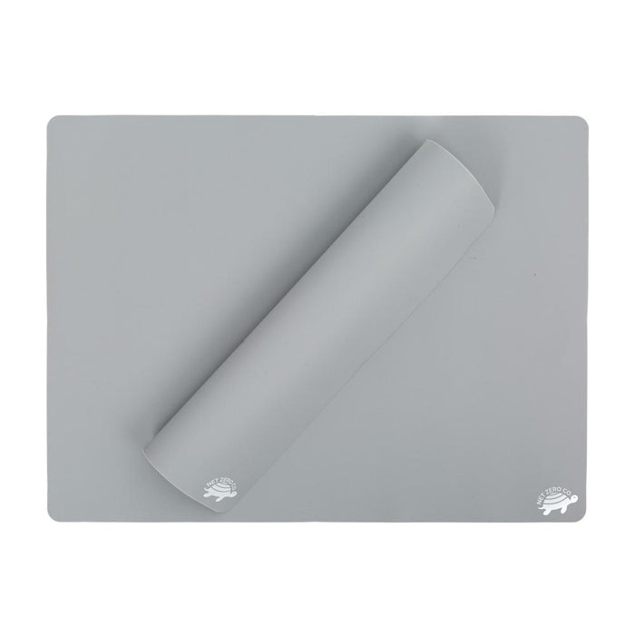 A gray rectangular silicone baking mat with one corner rolled inward. The mat has a small white hedgehog logo printed on two corners.