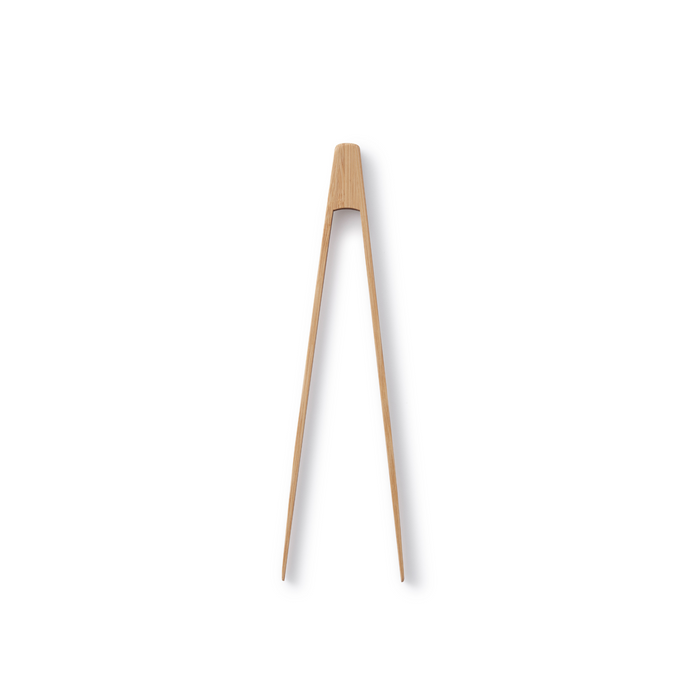 A single piece of light-colored wood carved into a pair of connected chopsticks, expanding at the top and tapering to pointed tips, set against a white background.