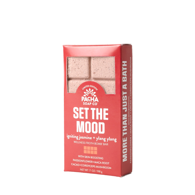 A red rectangular package of the Set the Mood Froth Bomb Bar by Pacha Soap Co. highlights More Than Just a Bath, featuring calming ingredients like jasmine, ylang ylang, passionflower, maca root, cacao, and cordyceps mushroom.