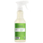 A spray bottle of Mrs. Meyer's Multi-Surface Cleaner features a green label, white nozzle, and product info. The back label highlights it as an essential oils cleaner.