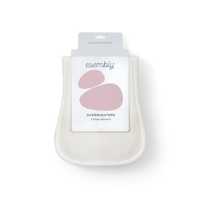 A package of Esembly Overnighters diaper boosters, featuring a white reusable cloth insert with rounded edges and a label displaying the brand name and abstract pink shapes.