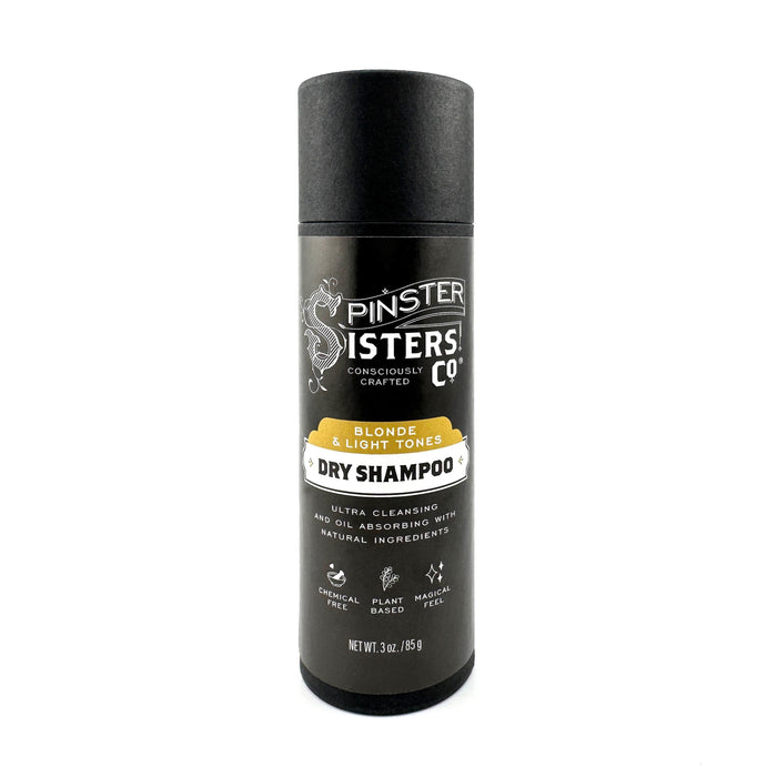 A cylindrical black container of Spinster Sisters Co. Dry Shampoo for blonde and light tones, featuring white and yellow text, and labeled as plant-based, chemical-free, and ultra cleansing.