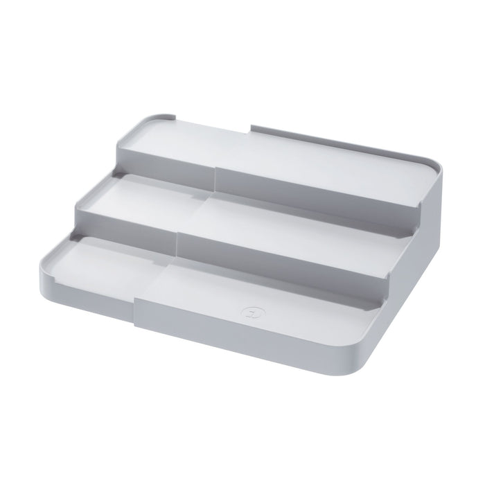 A gray, three-tiered plastic organizer tray with rounded corners and a flat base, designed for storing and displaying small items.