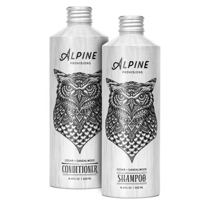 Two cylindrical bottles feature owl illustrations and a wood-like texture. The left bottle is a natural hair care conditioner, the right is shampoo, both by Alpine Provisions. They hold 16.9 fl oz (500 ml) and are cedar and sandalwood-scented from the Shampoo and Conditioner Set - Cedar Sandalwood.