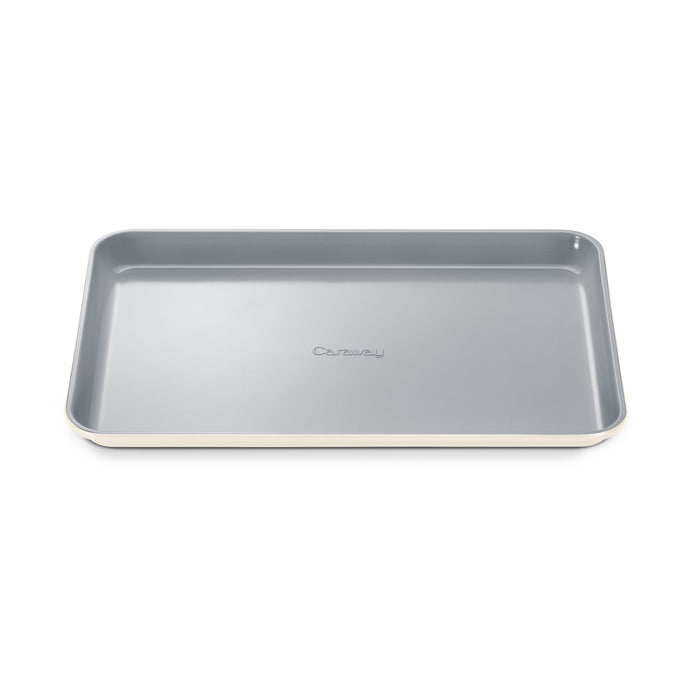 A rectangular, light gray baking sheet with rounded corners and slightly raised edges. The word Caraway is embossed in the center of the sheet. The sheet has a smooth, nonstick surface.