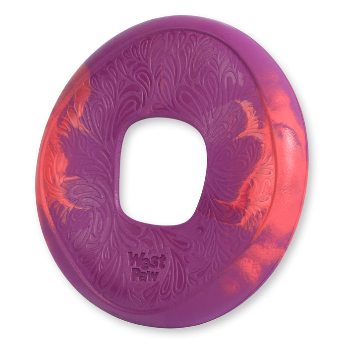 A circular, purple and orange dog toy with a textured paisley pattern and a large hole in the center. The words West Paw are embossed on the surface.
