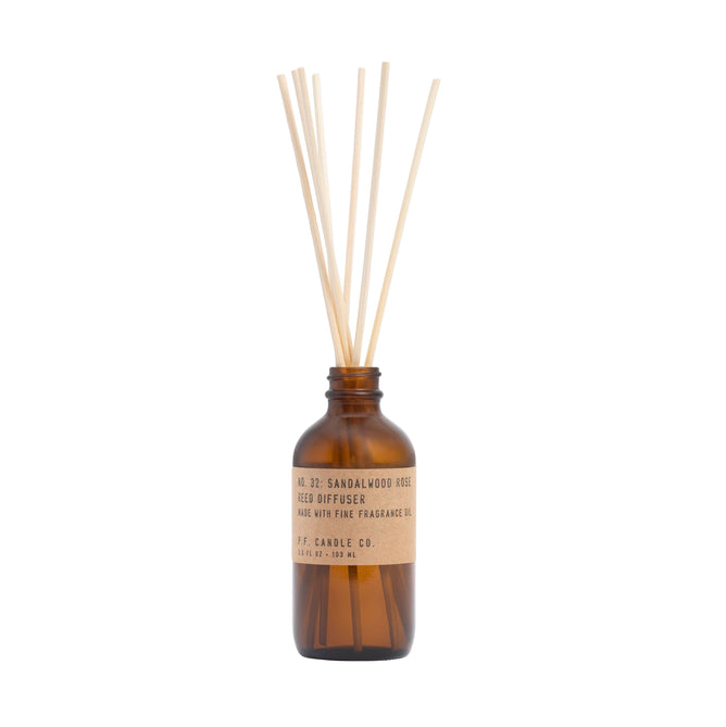 A brown glass P.F. Candle Co. Reed Diffuser labeled No. 32: Sandalwood Rose, features light wooden reeds, enhanced with teakwood hints, and made with fine fragrance oil.