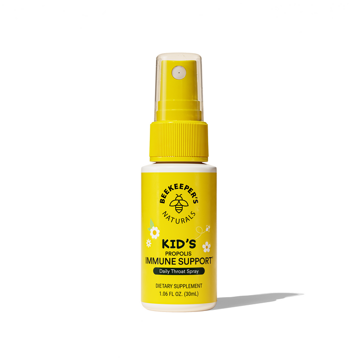 A yellow spray bottle labeled Beekeepers Naturals Kids Propolis Immune Support Daily Throat Spray standing upright on a white background.