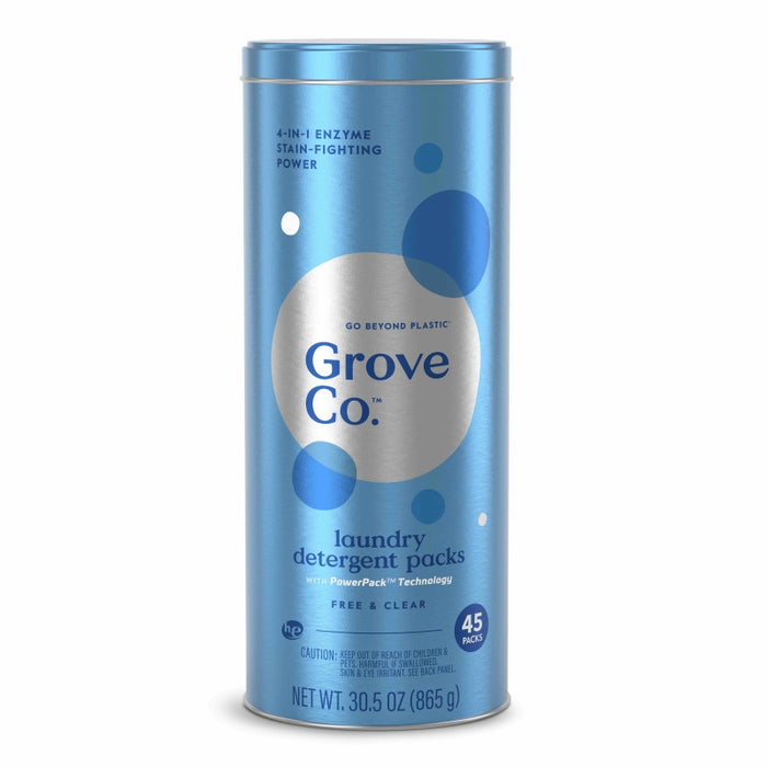 A tall, cylindrical blue container labeled Grove Co. laundry detergent packs. It holds 45 free & clear packs, features 4-in-1 enzyme stain-fighting power, and weighs 30.5 oz (865g). The design includes white and blue circles.