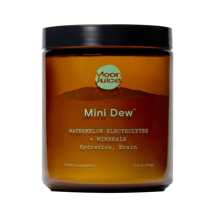 A brown jar labeled Moon Juice Mini Dew contains a dietary supplement with watermelon electrolytes and minerals for hydration and brain health. The jar has a black lid and minimal teal and white text.