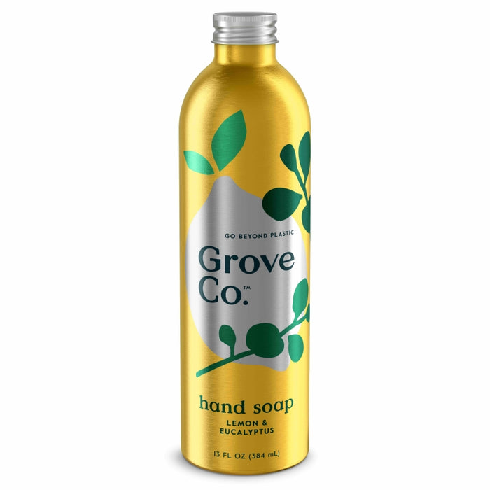 A metallic gold bottle of Grove Co. hand soap with green leaves design and text reading “GO BEYOND PLASTIC,” “Grove Co.,” and “hand soap, lemon & eucalyptus, 13 fl oz (384 mL).”.