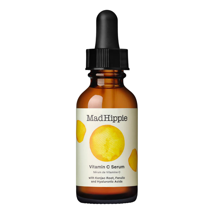 A brown glass dropper bottle labeled Mad Hippie Vitamin C Serum with a black dropper cap and yellow circle designs on the label.