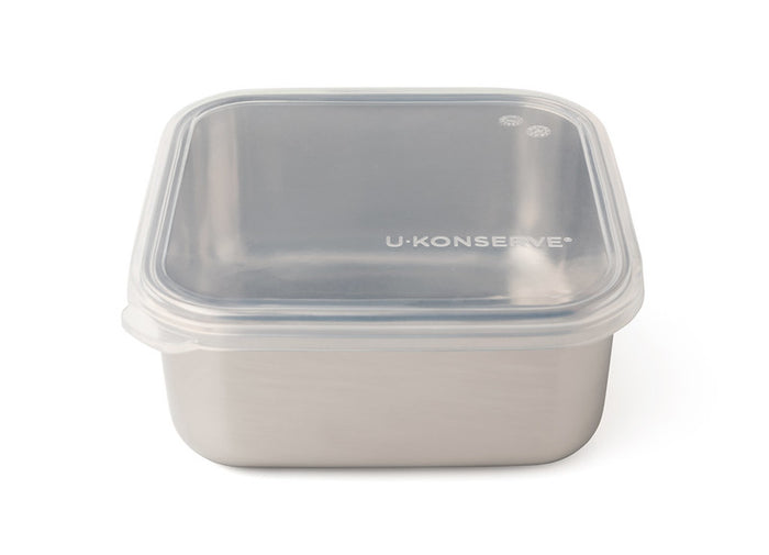 A square stainless steel food container with a clear plastic snap-on lid, featuring the brand name U Konserve printed on top.