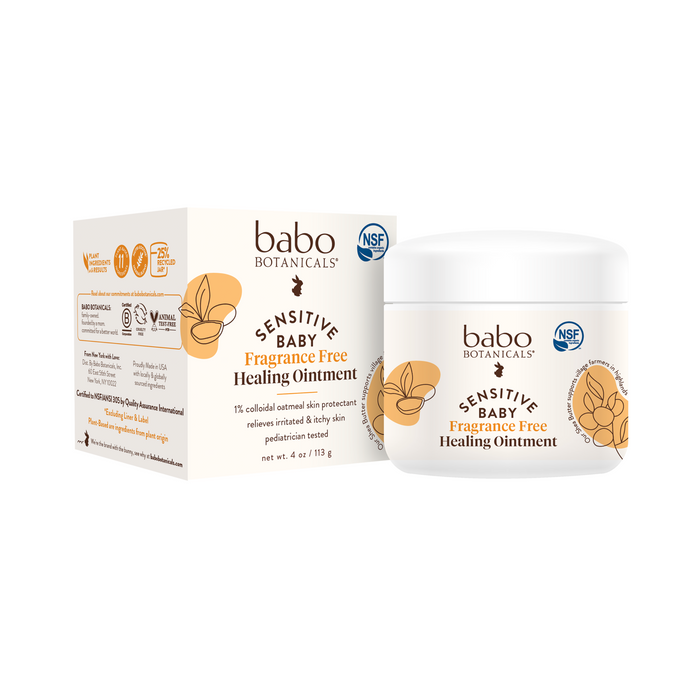 A white container and box of Babo Botanicals Sensitive Baby Fragrance Free Healing Ointment with gold and brown leaf designs and NSF certification logos, positioned against a white background.