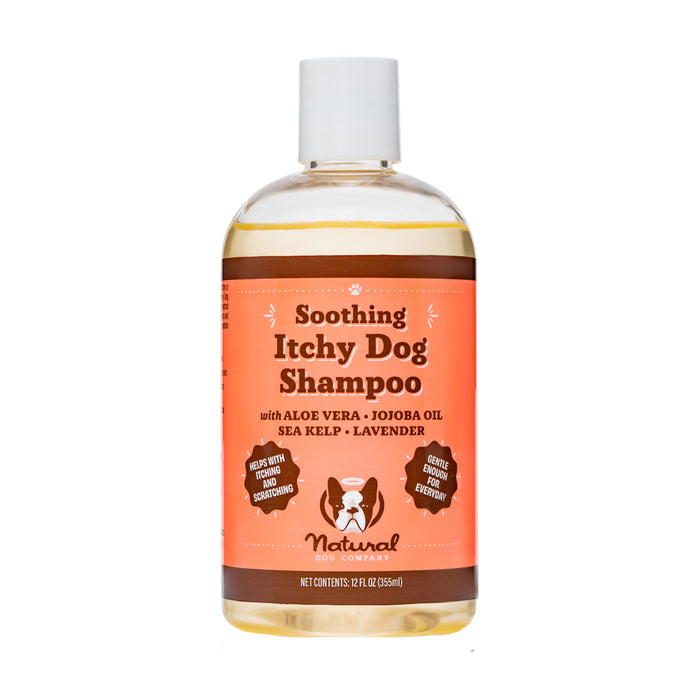 A clear bottle of Natural Dog Company Soothing Itchy Dog Shampoo with an orange label featuring text about its ingredients, including aloe vera, jojoba oil, sea kelp, and lavender.