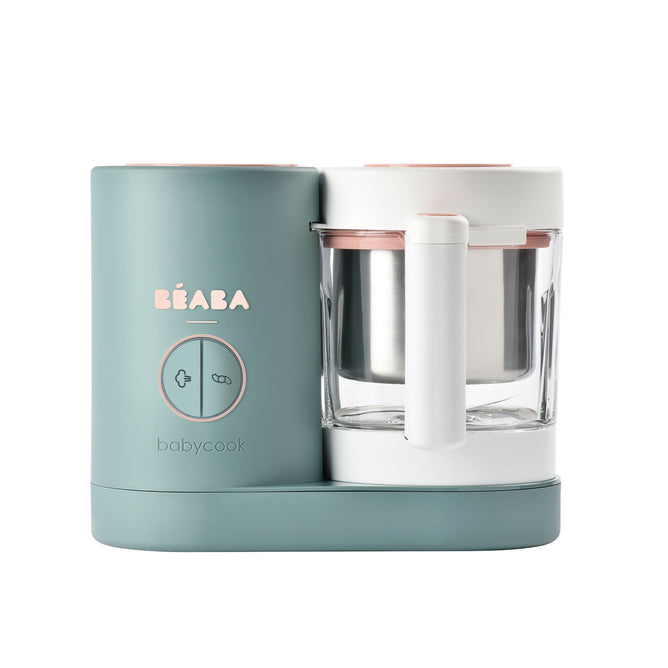 A Béaba Babycook baby food maker in pastel green and white, featuring a blending container with handle, and control buttons on the front.