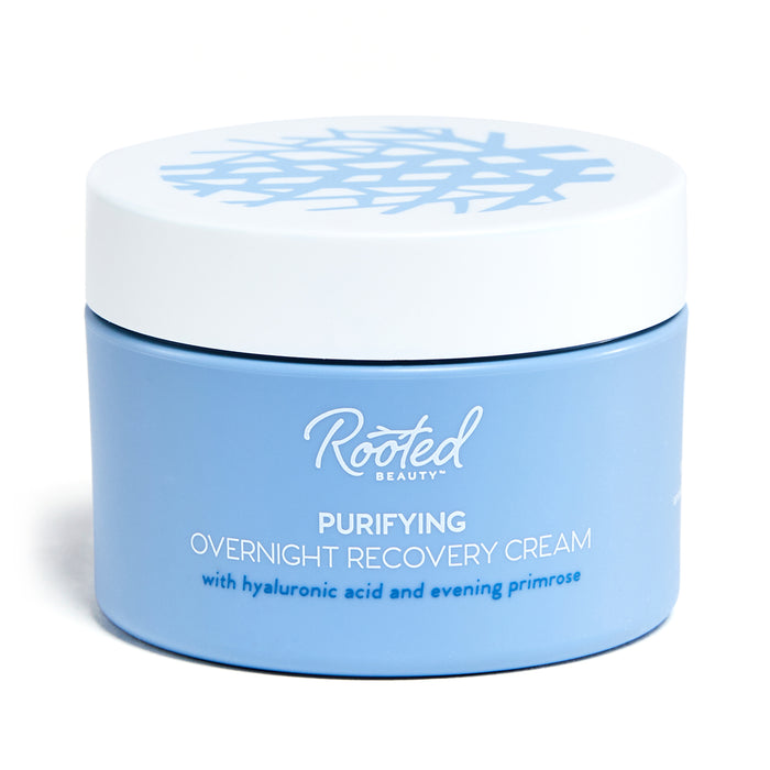 A light blue jar labeled Rooted Beauty Purifying Overnight Recovery Cream with hyaluronic acid and evening primrose, with a white lid featuring a blue abstract pattern.