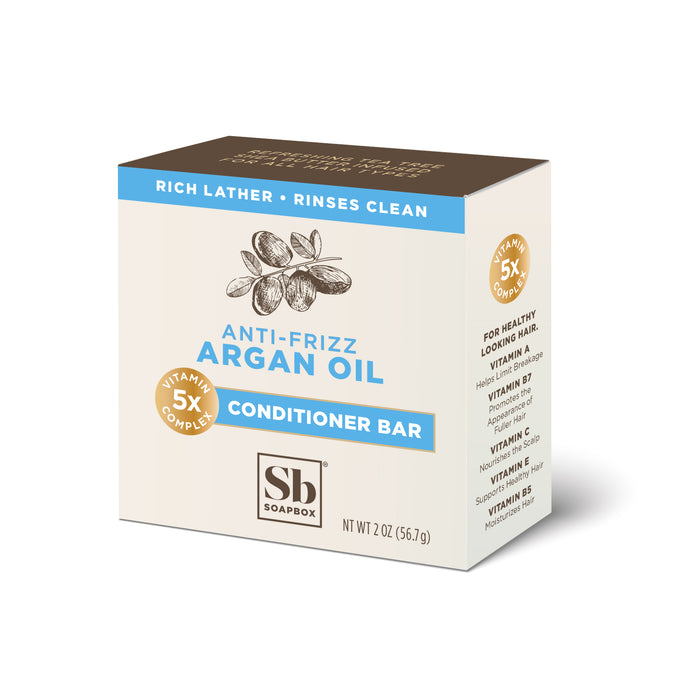 A box of Soapbox Anti-Frizz Argan Oil Conditioner Bar featuring a picture of argan nuts, details about “Vitamin 5X Complex,” and text highlighting rich lather and clean rinsing. Net weight is 2 oz (56.7g).