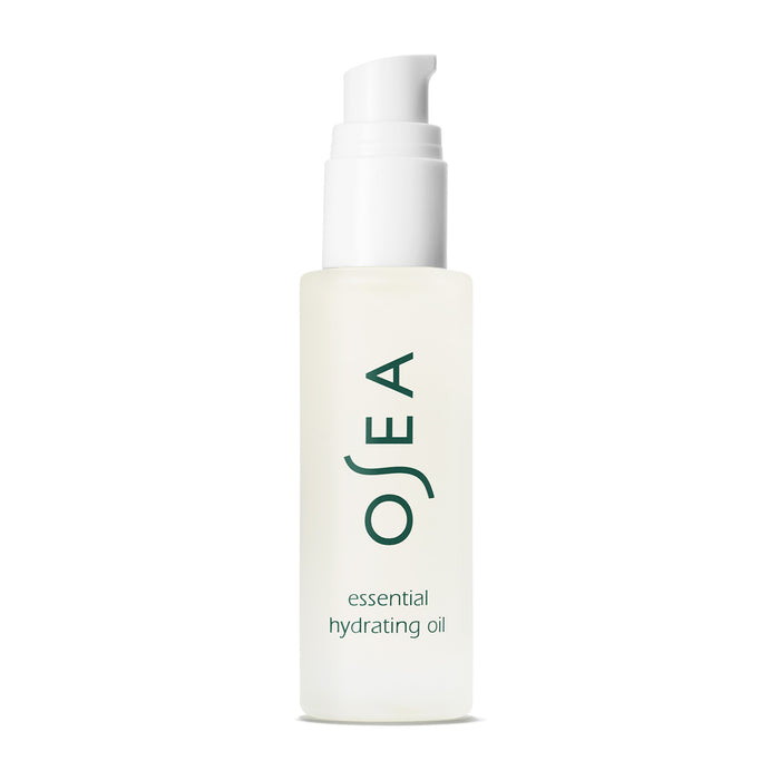 A frosted glass bottle of OSEA Essential Hydrating Oil with a white pump dispenser and green text on the front, displayed on a white background.
