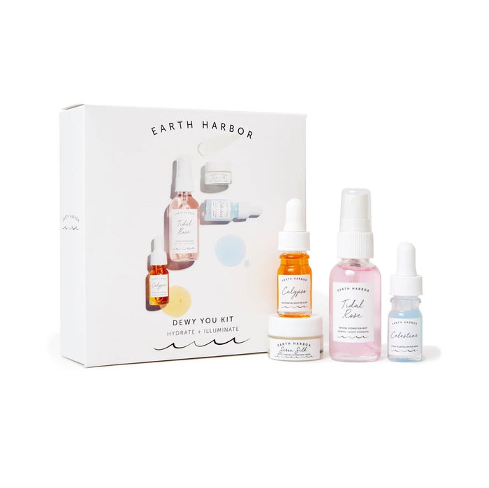 A skincare set called Dewy You Kit by Earth Harbor, featuring a box and four small bottles and jars of skincare products in various pastel colors, displayed in front of the packaging.