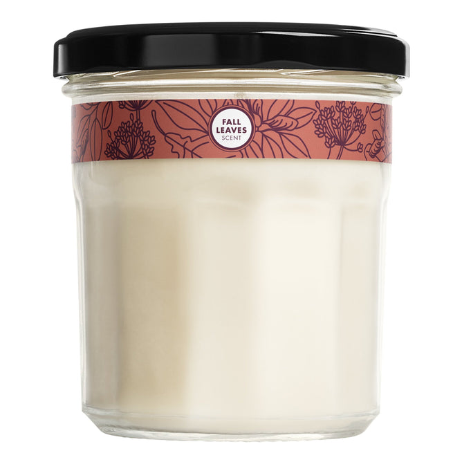 The Mrs. Meyers Soy Glass Jar Candle comes in a glass jar with a black lid and is made from cruelty-free soy wax. It features an off-white candle with a floral-patterned label on a brown background, labeled Fall Leaves Scent.