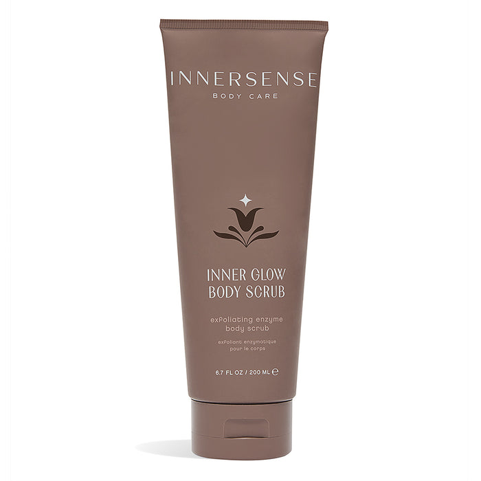 A brown tube of Innersense Body Care Inner Glow Body Scrub with white text and a minimalist leaf logo, standing upright against a white background.