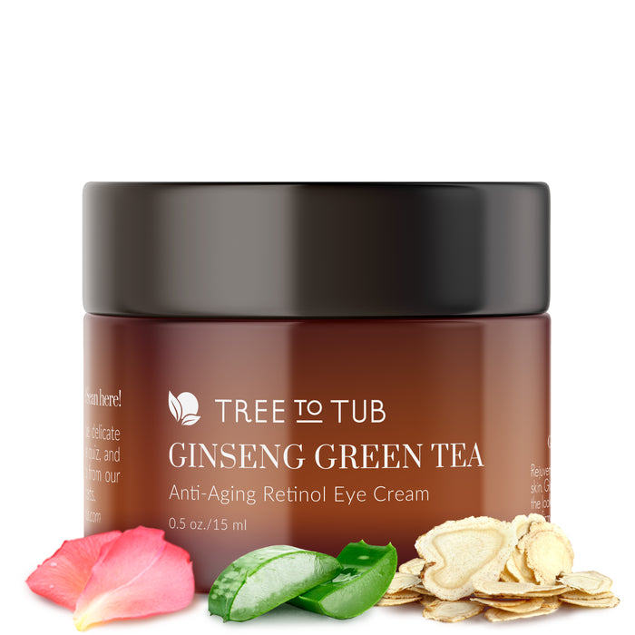 A brown jar labeled Tree to Tub Ginseng Green Tea Anti-Aging Retinol Eye Cream with a black lid, surrounded by rose petals, an aloe vera leaf, and oats. The jar size is 0.5 oz / 15 ml.
