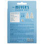 Back of a Mrs. Meyer's Scented Oil Refills 2pk package, blue with white text. Features product details, instructions, safety warnings, images of two garden-inspired refill bottles, barcodes, and various symbols.