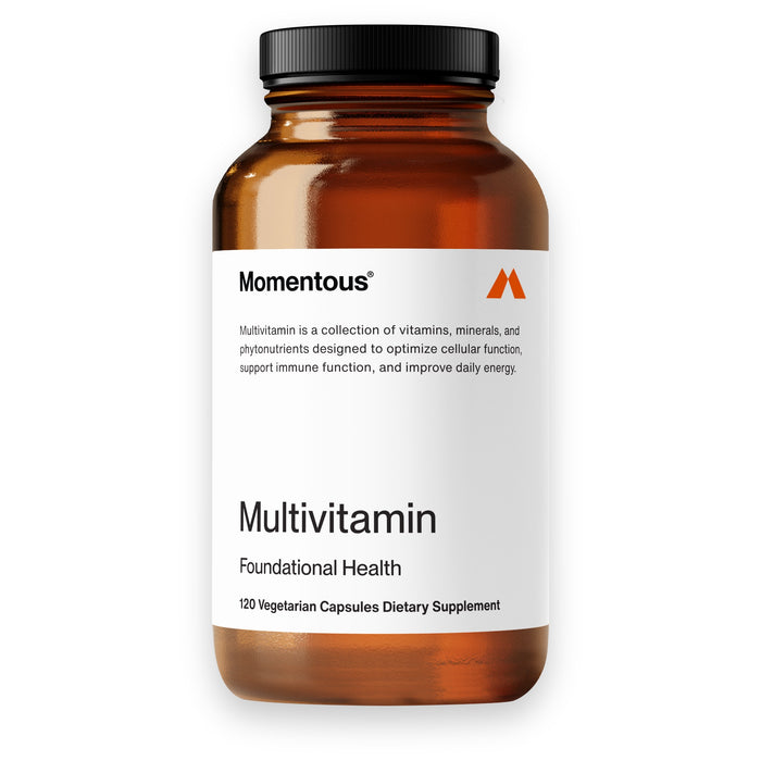 A brown bottle labeled “Momentous Multivitamin Foundational Health” contains 120 vegetarian capsules. The white label describes it as a supplement for cellular function, immune support, and daily energy.