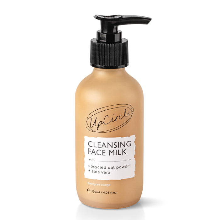 A tan bottle with a black pump labeled UpCircle Cleansing Face Milk with upcycled oat powder and aloe vera, 120ml size. The bottle features simple, modern design and white label.