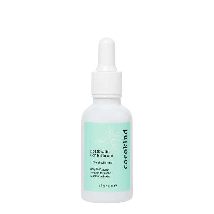 A white bottle of Cocokind Postbiotic Acne Serum with a dropper cap and a green label, containing 1% salicylic acid for clear and balanced skin.