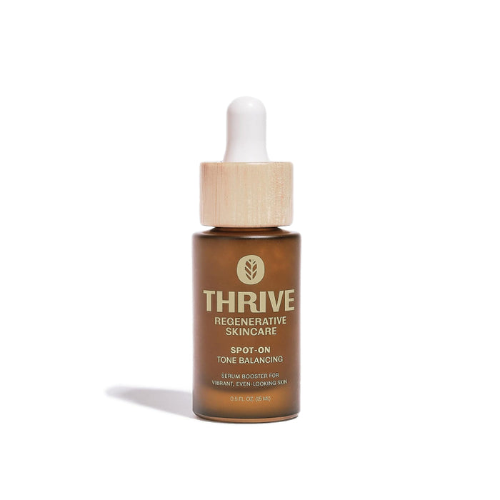 A brown glass bottle with a wooden dropper cap labeled Thrive Regenerative Skincare Spot-On Tone Balancing serum booster for vibrant, even-looking skin, 0.8 fl oz (24 ml), standing upright on a white background.