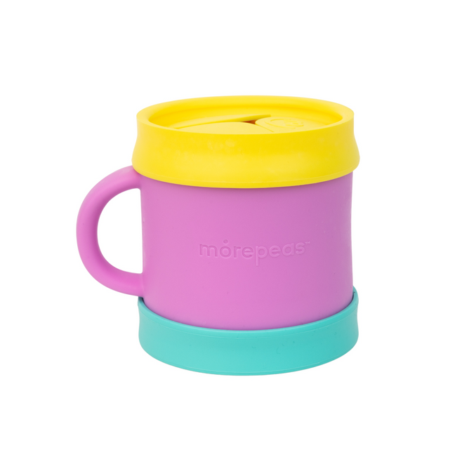 A colorful cup with a pink body, yellow lid, blue base, and pink handle. The word morepeas is embossed on the side. The cup sits on a white background.