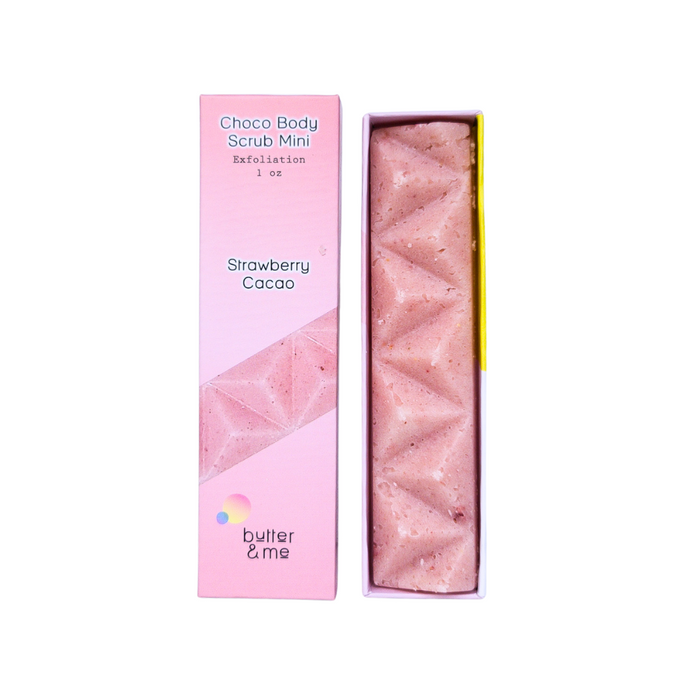 A pink rectangular bar labeled Choco Body Scrub Mini Strawberry Cacao in an open pink box. The scrub bar has a geometric pattern, and the box displays the brand name butter & me.